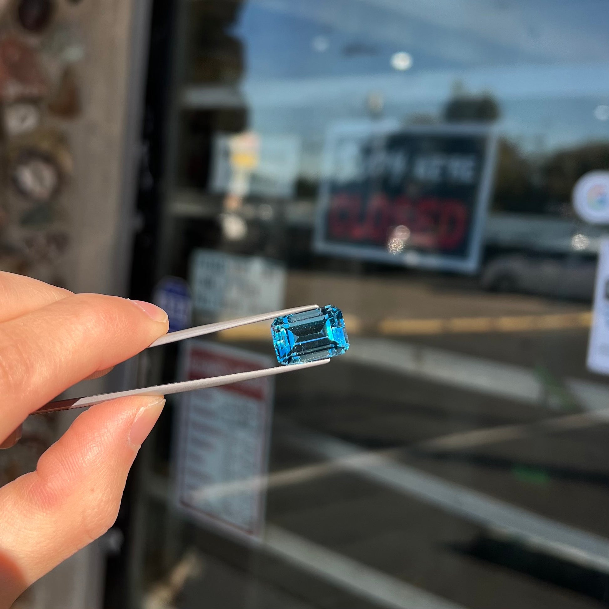 A loose, emerald cut London blue topaz gemstone.  The stone is a deep, dark blue color.