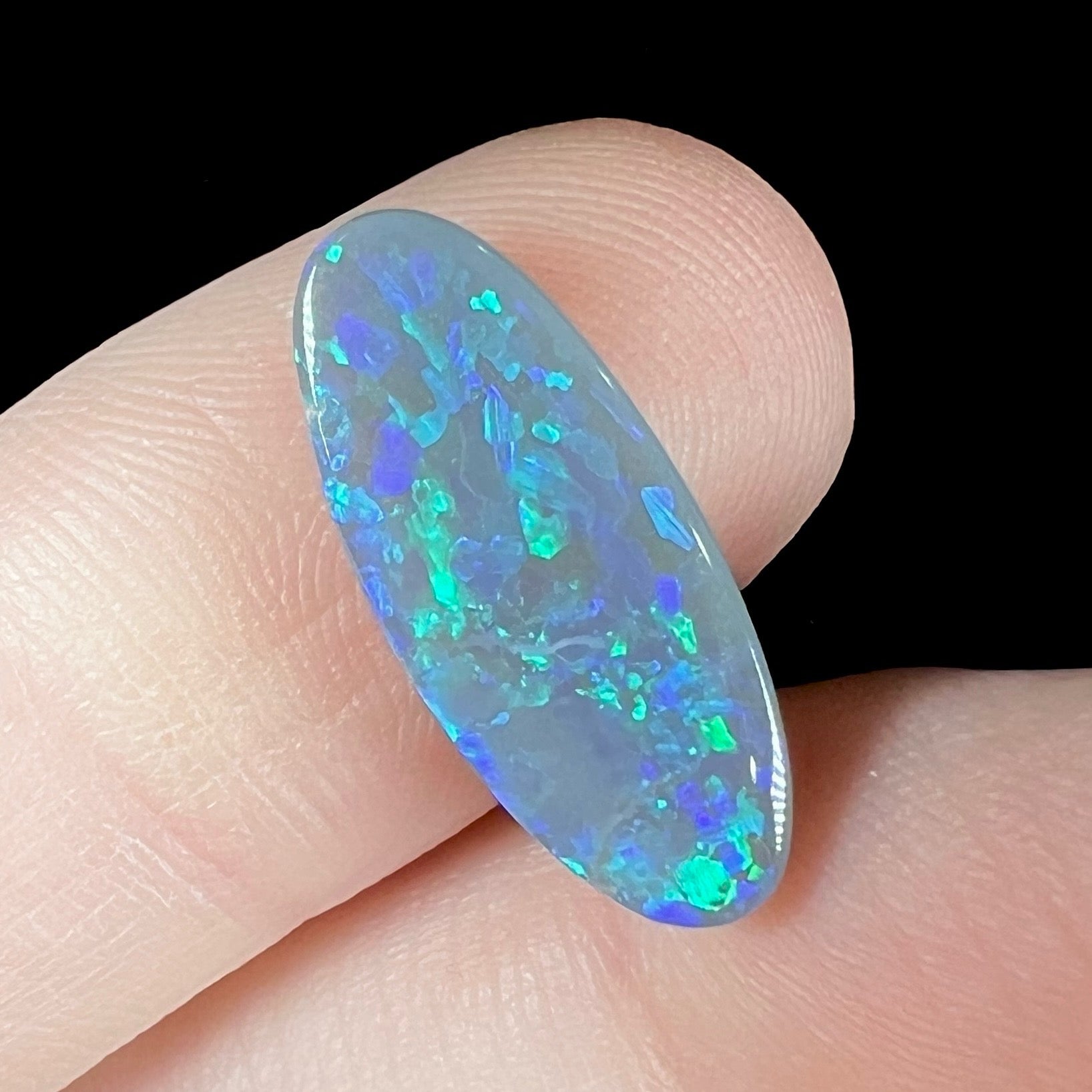 A loose black opal stone from Lightning Ridge, Australia.