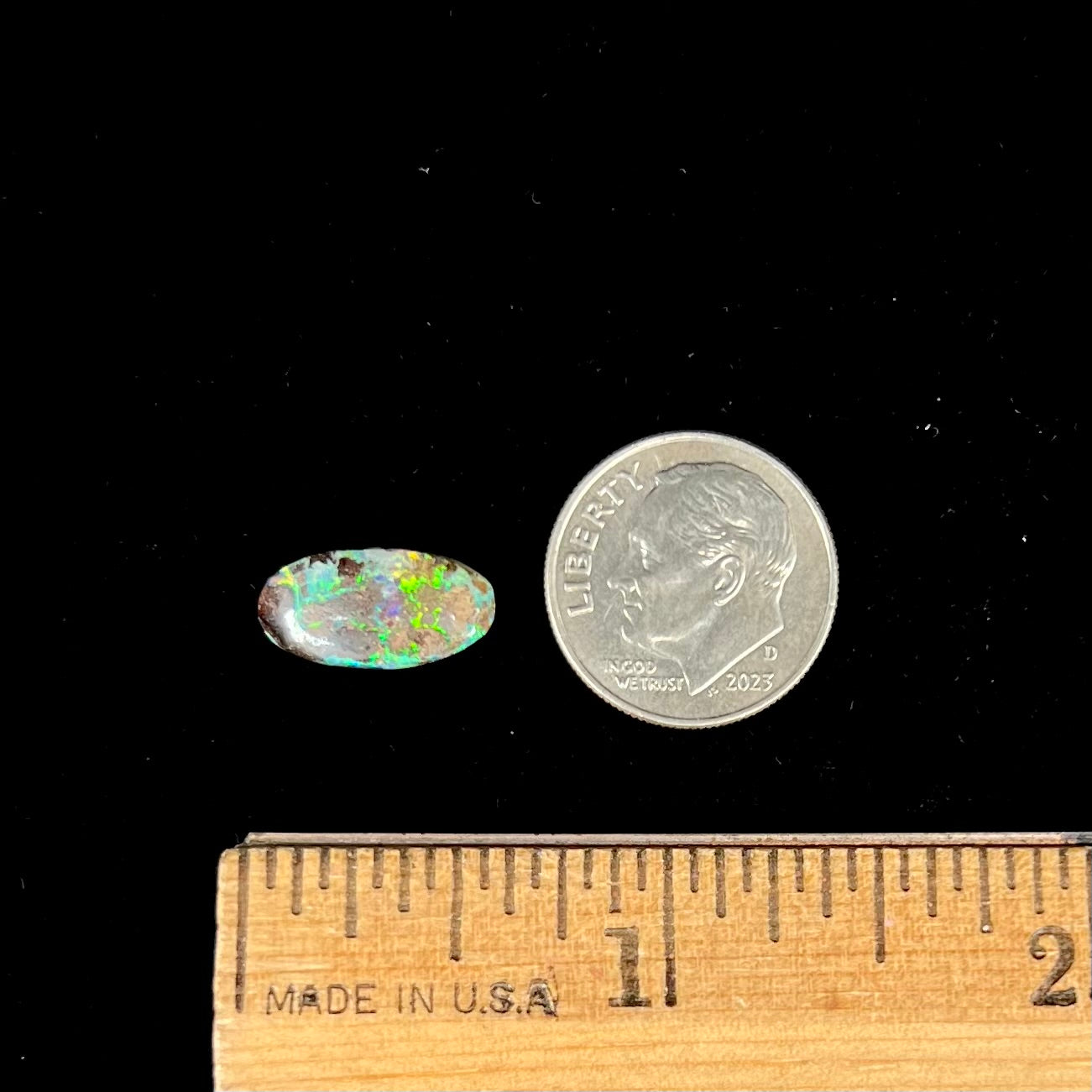 A loose, oval cabochon cut Koroit boulder opal stone.  The opal has a bright green color.