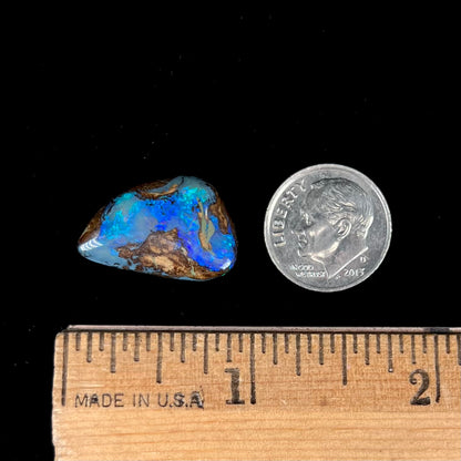 A freeform pear shaped boulder opal stone with blue color.