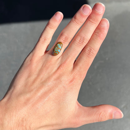 An oval cabochon cut boulder opal stone from Koroit, Australia.  The opal has a blue color.