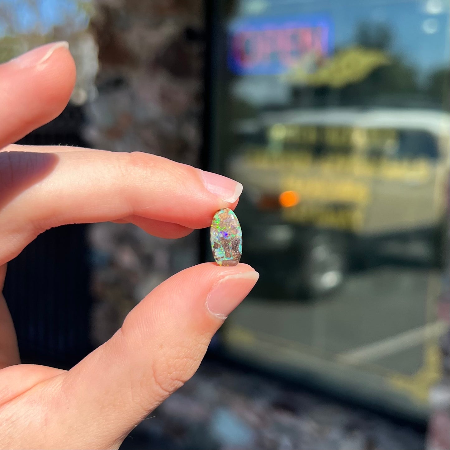 A loose, oval cabochon cut Koroit boulder opal stone.  The opal has a bright green color.