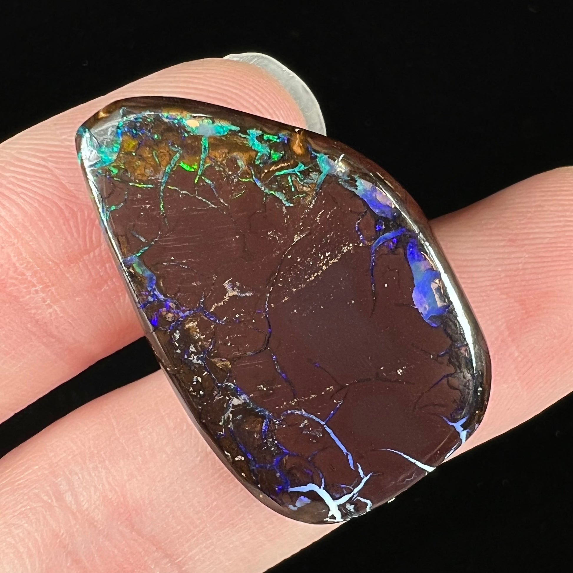 A freeform shaped boulder opal stone from Koroit, Australia.