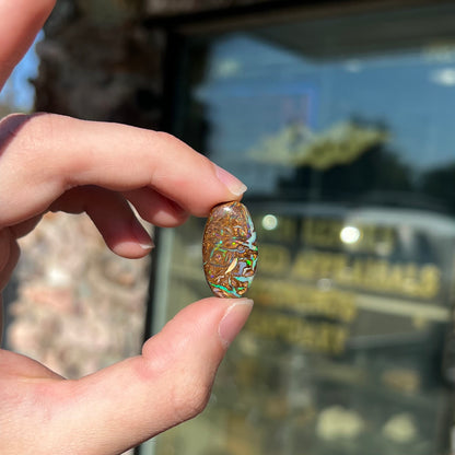 A loose, oval shaped Koroit boulder matrix opal.  The stone has patterns that resembles a rose.