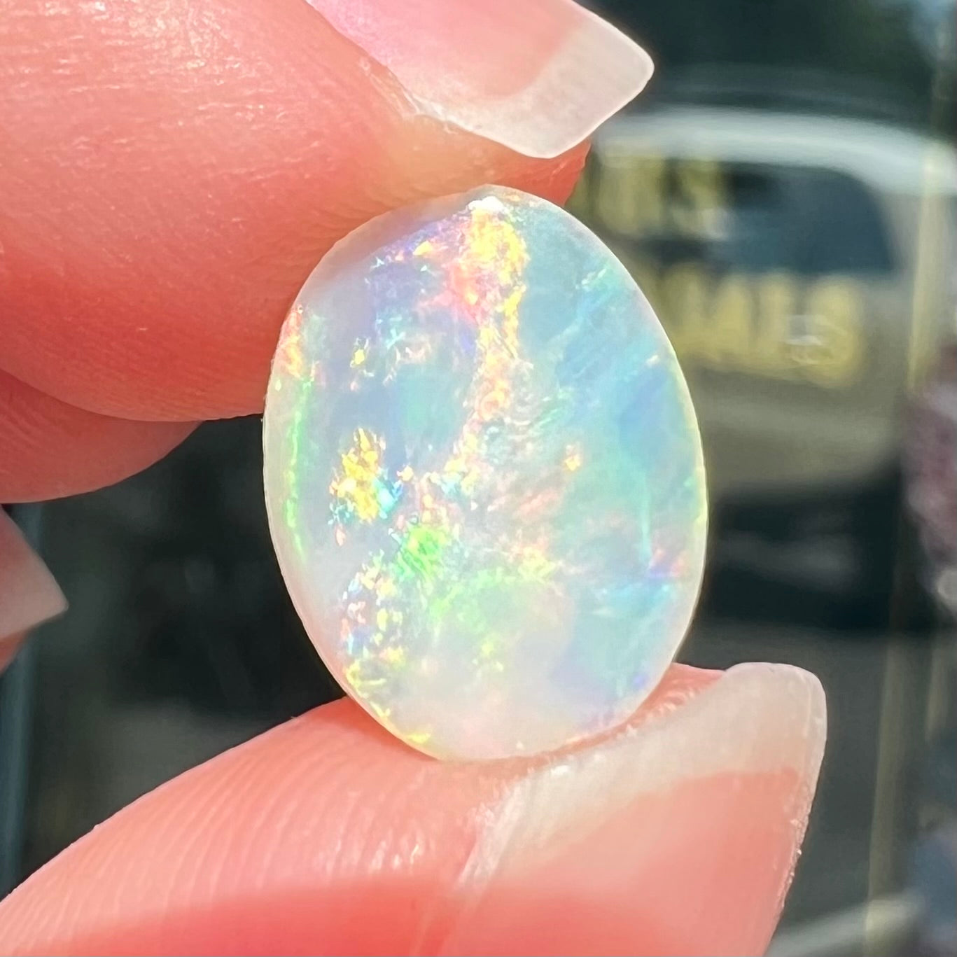 An oval cut opal with red, green, and blue fire from Coober Pedy, Australia.