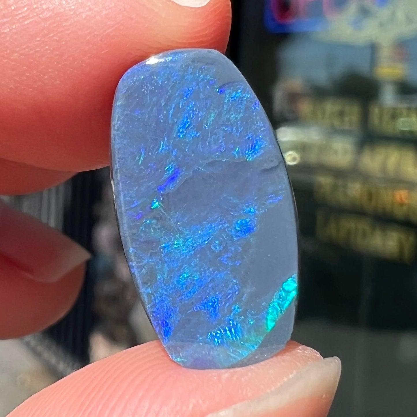 A loose, barrel shaped black opal stone from Lightning Ridge, Australia that weighs 5.25 carats.