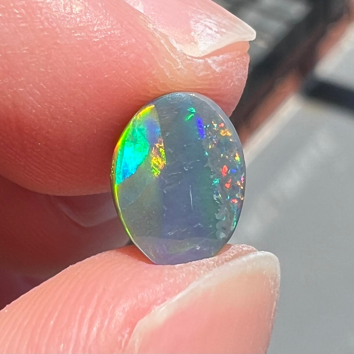 A loose, oval cut black opal from Lighting Ridge, Australia.  The stone is highly directional.