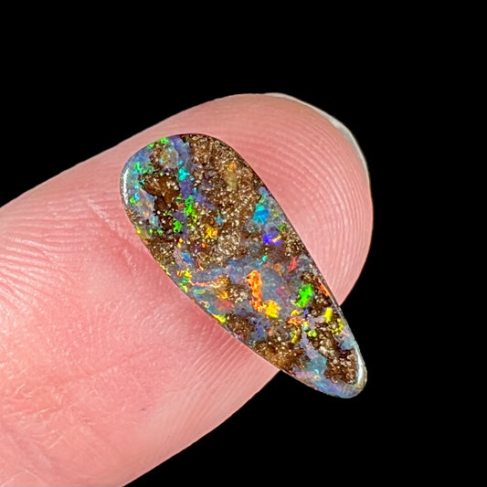 A loose, pear shaped boulder opal stone from Quilpie, Australia.  The opal shines every color of the rainbow.