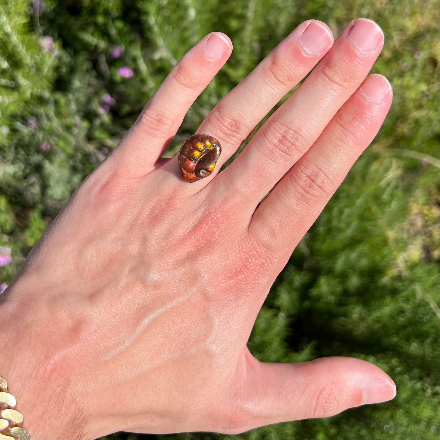 A large Mexican fire agate gemstone.  The stone is red with green iridescence and a waxy luster.