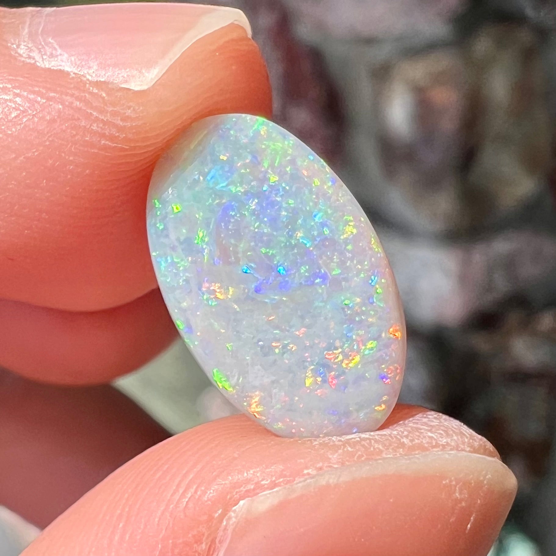 A semi-black, small flashfire opal stone from Mintabie, Australia.