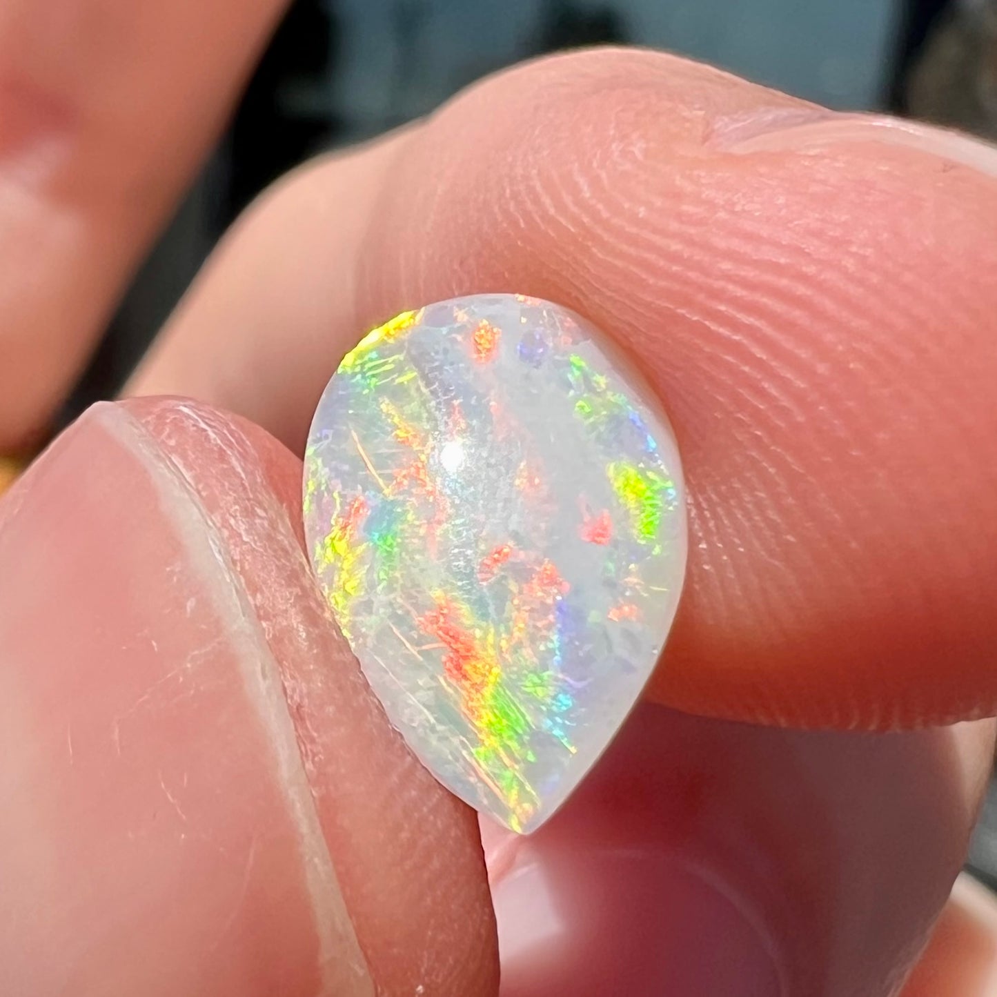 A loose, pear shaped Australian white opal stone.  The stone plays every color of the rainbow.