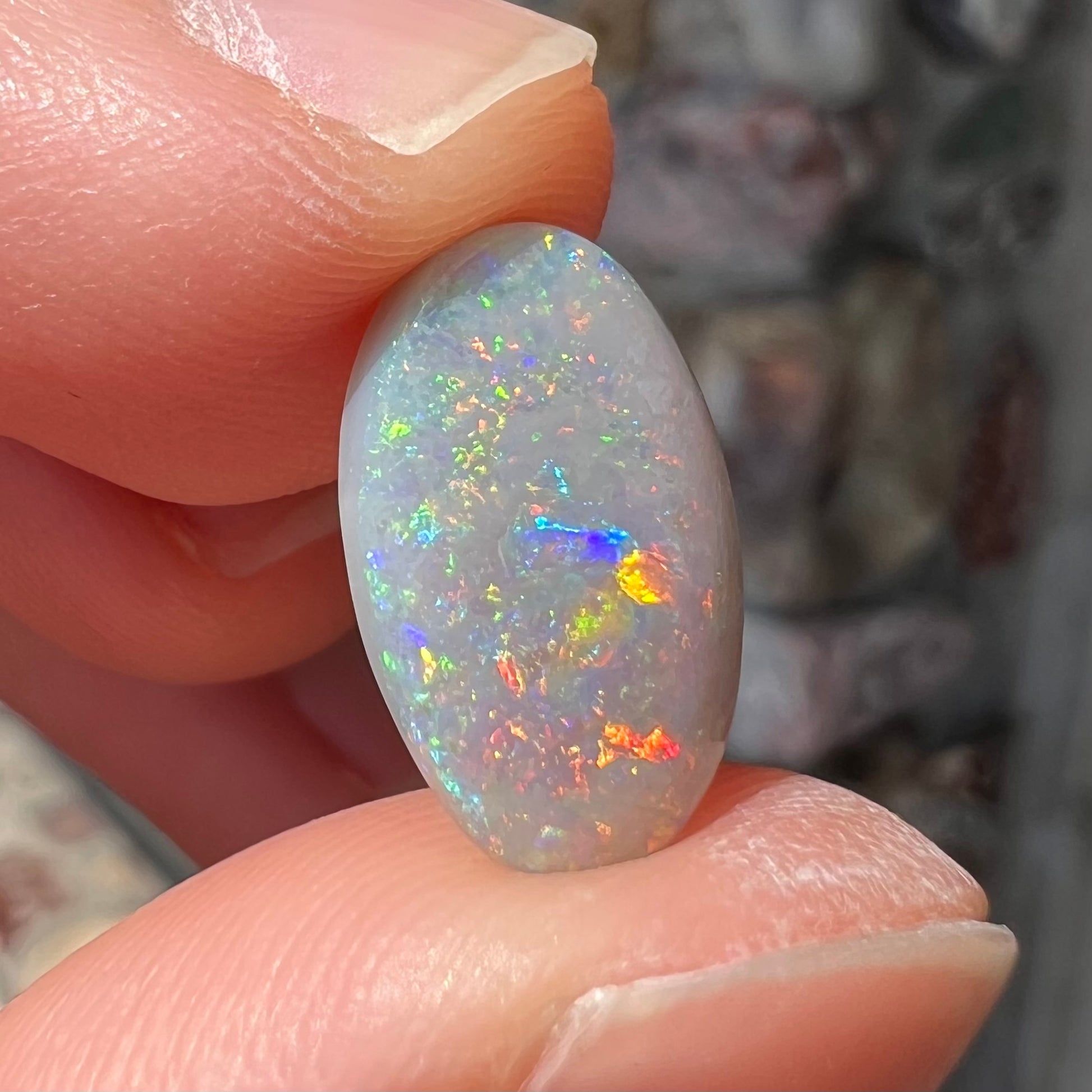 A semi-black, small flashfire opal stone from Mintabie, Australia.