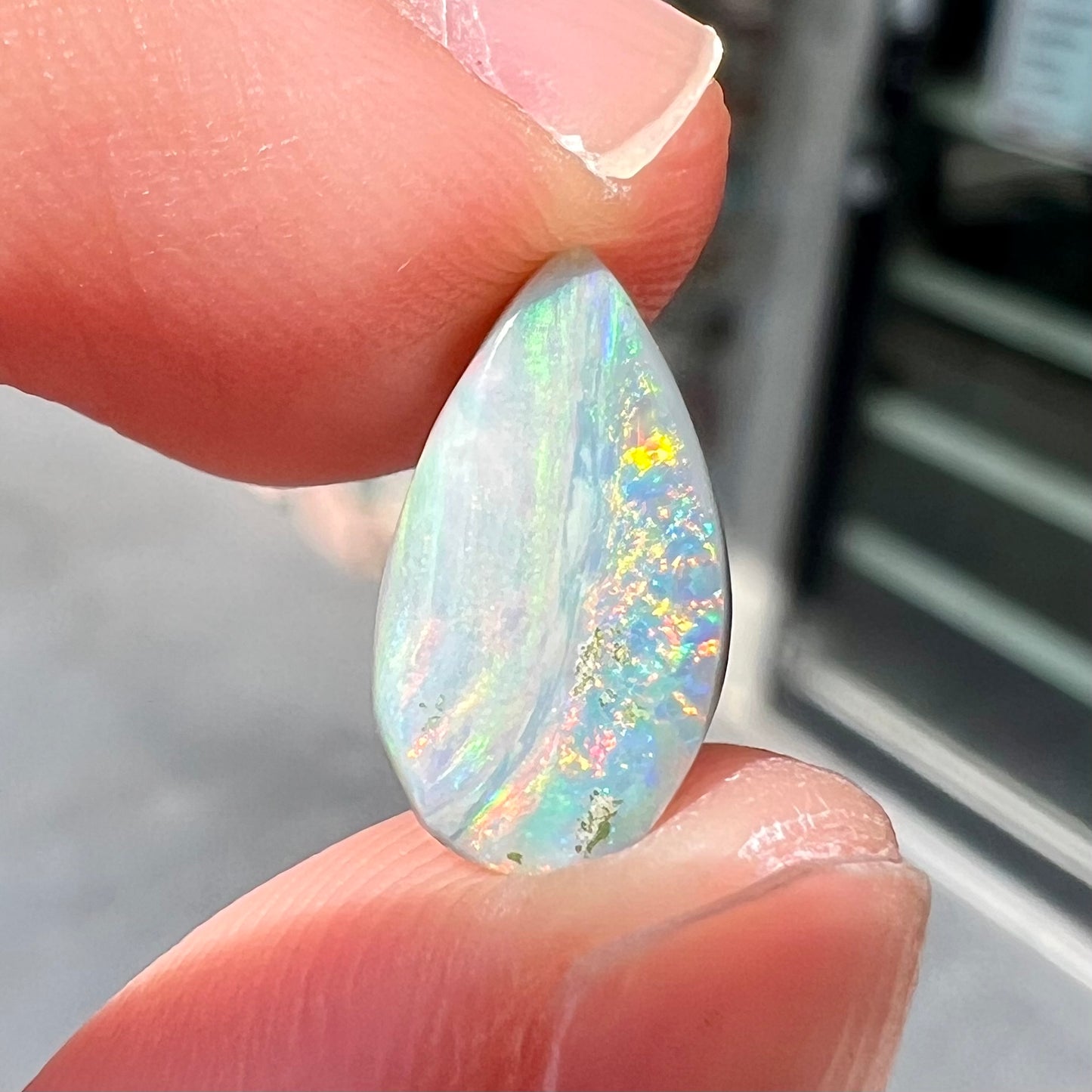 A loose, pear shaped Australian opal stone.  The opal shows green and blue colors.