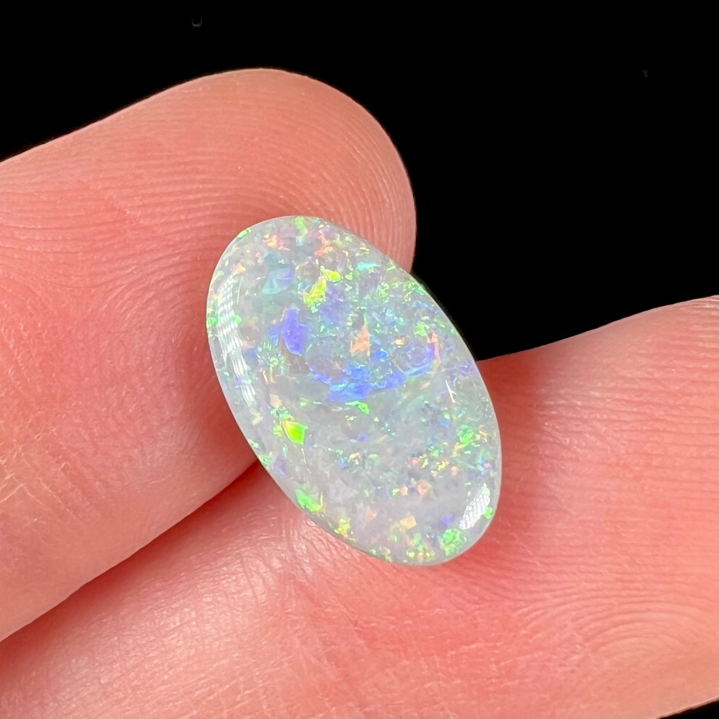 A semi-black, small flashfire opal stone from Mintabie, Australia.