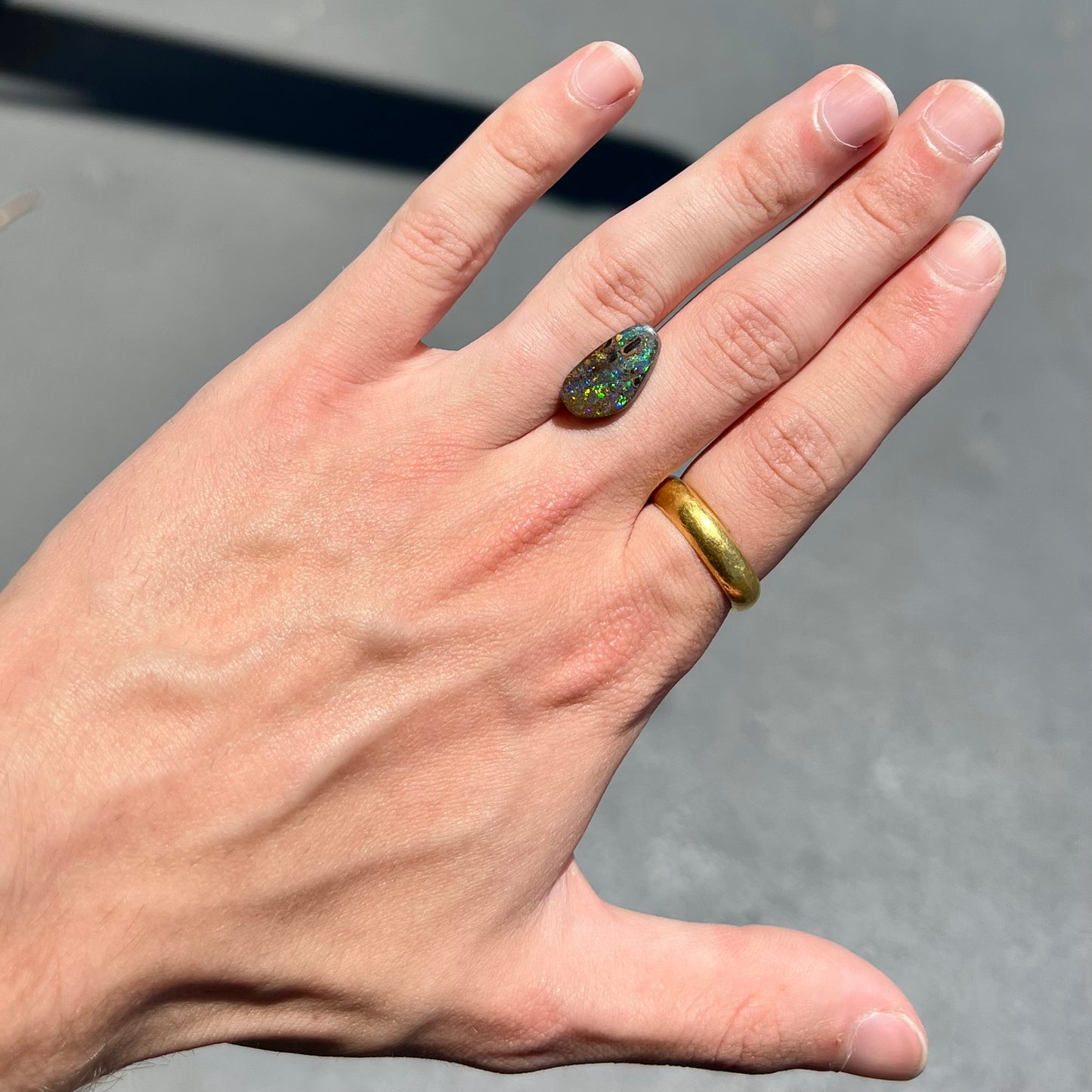 A loose boulder opal stone from Quilpie, Australia.  The opal shines colors of green and orange.