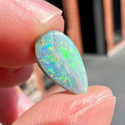 A loose, pear shaped Australian opal stone.  The opal shows green and blue colors.