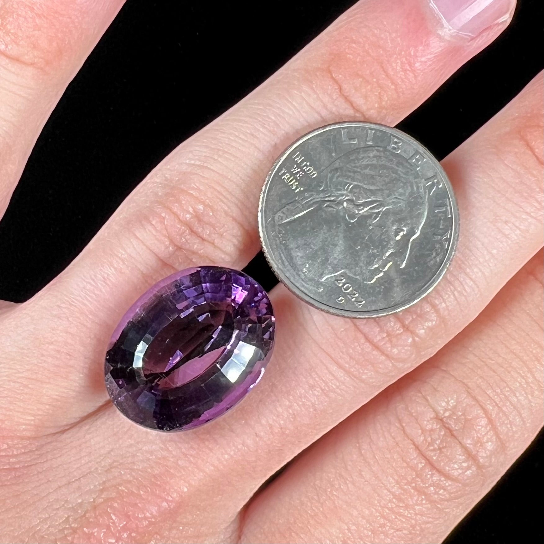 A loose, modified oval step cut amethyst gemstone.  There are light scratches to the table.