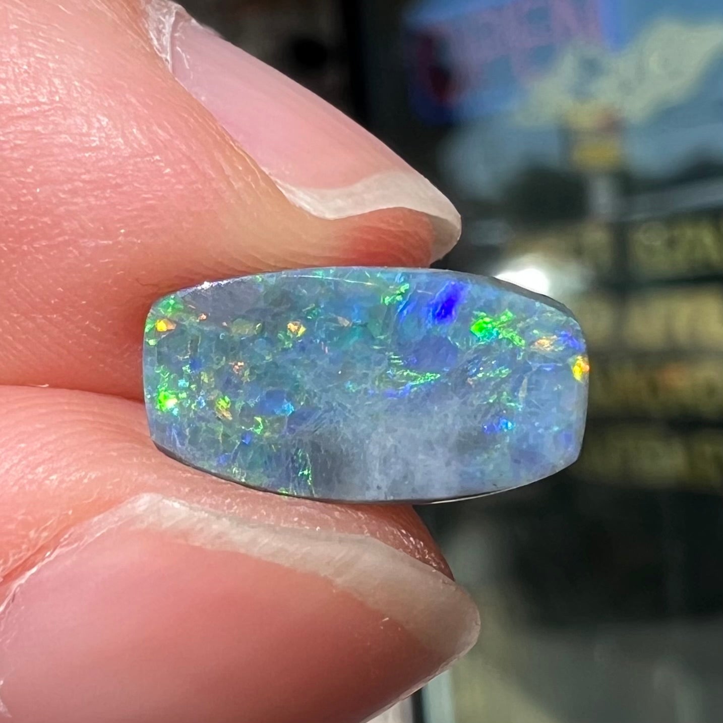 A loose 1.76ct barrel shaped black opal stone from Lightning Ridge, Australia.  The opal has a rainbow of colors.