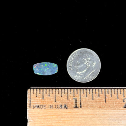 A loose 1.76ct barrel shaped black opal stone from Lightning Ridge, Australia.  The opal has a rainbow of colors.