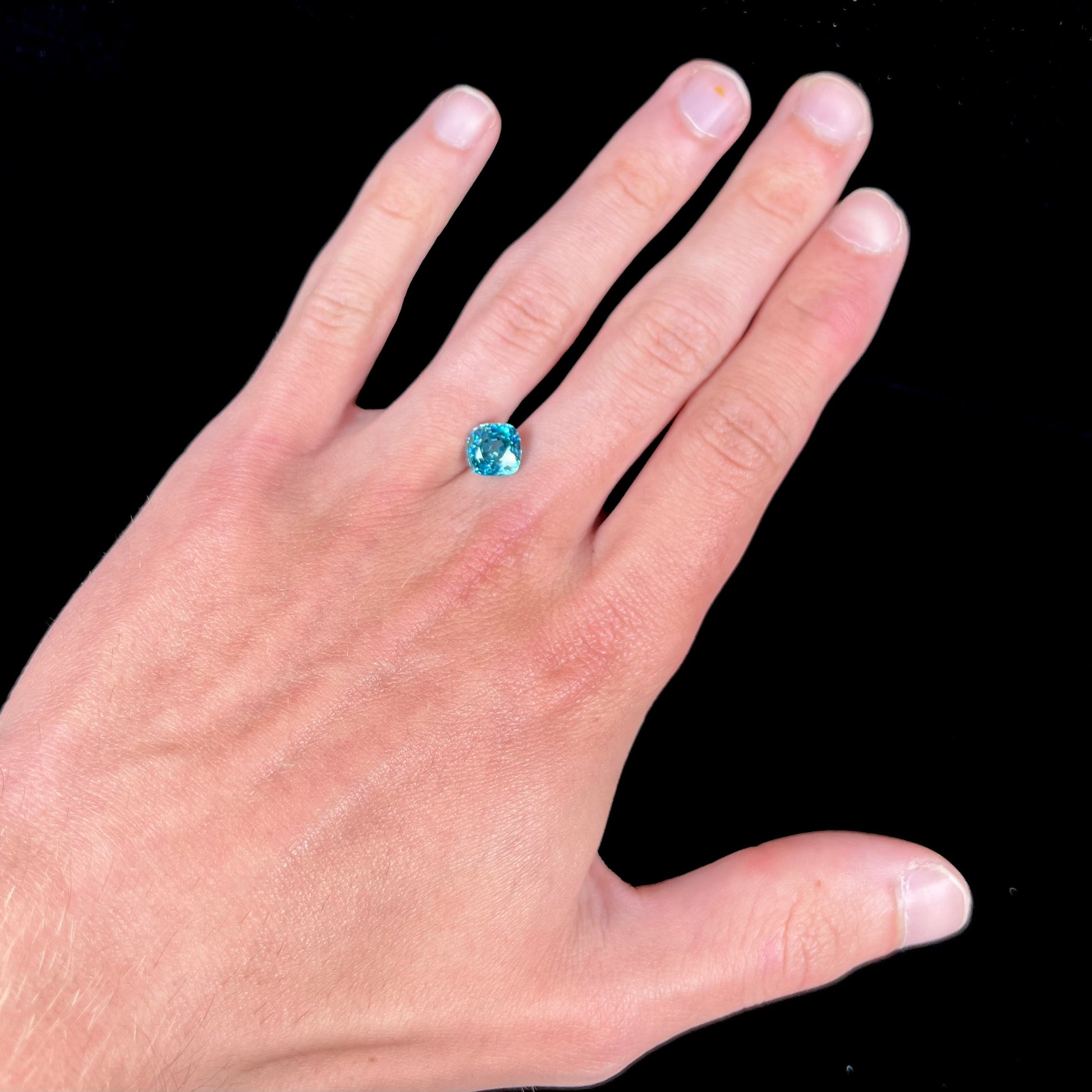 A loose cushion cut blue zircon stone.