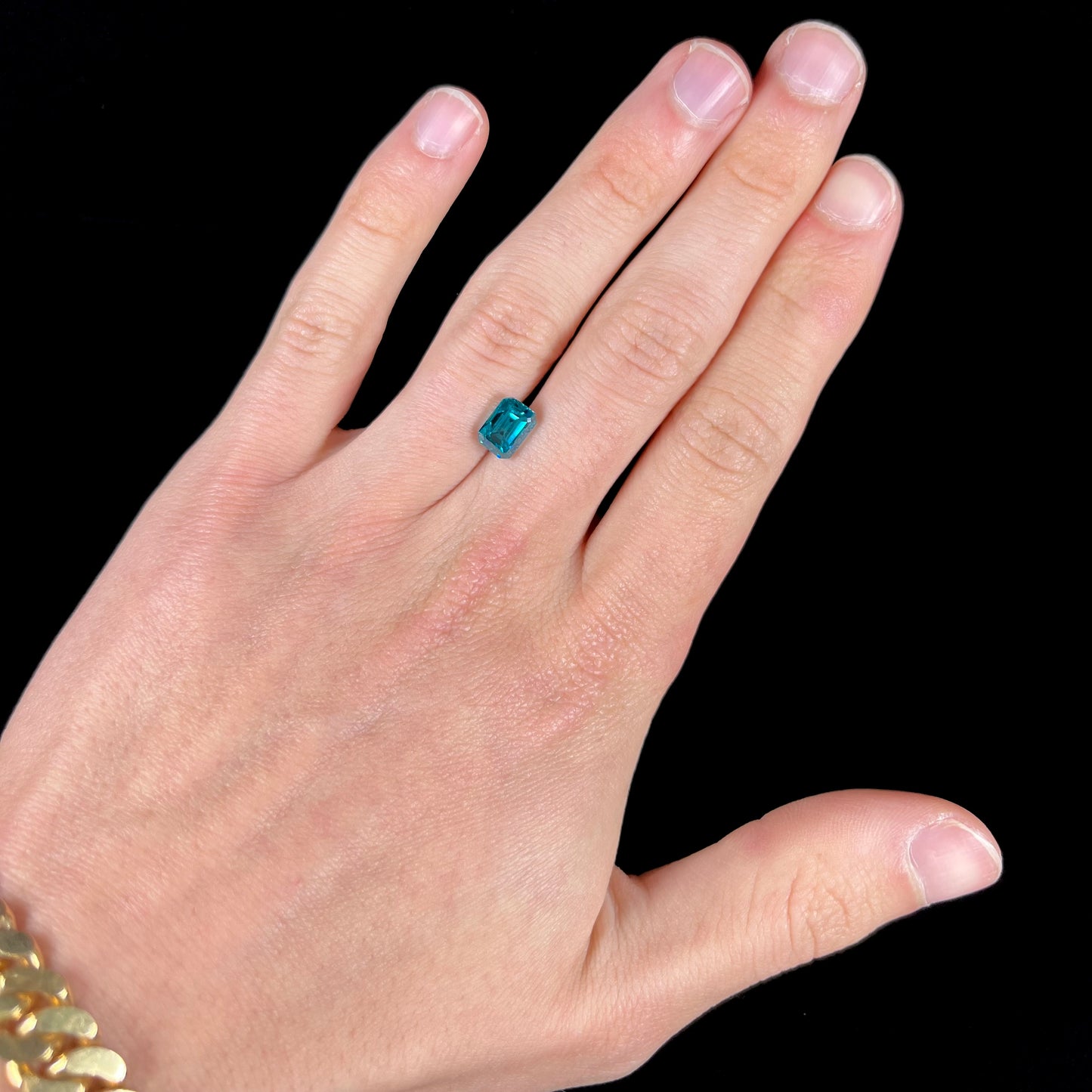 A natural blue zircon gemstone.  The stone is emerald cut.