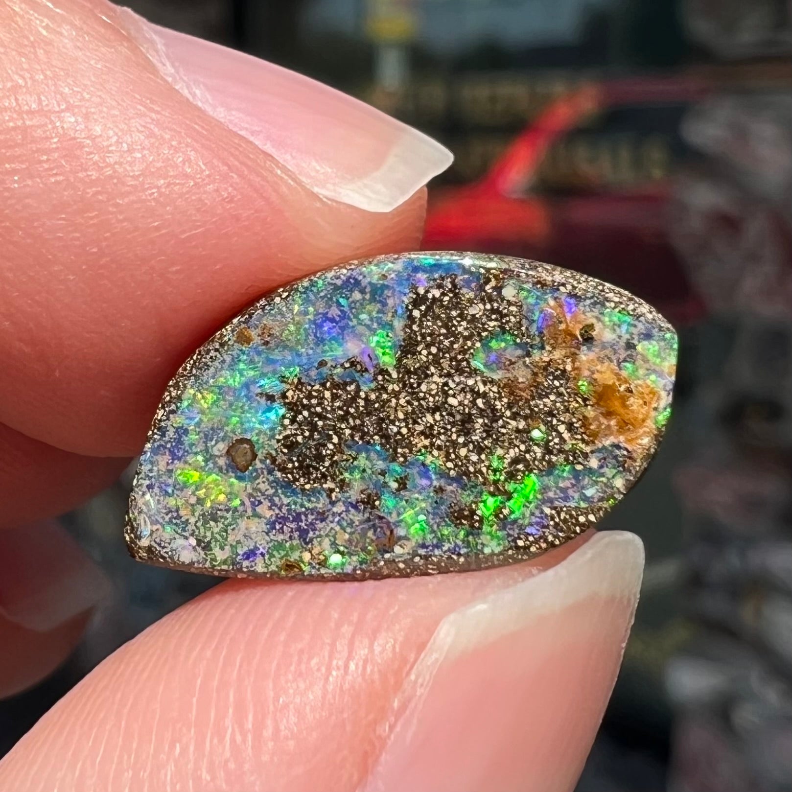 A loose boulder opal stone from Quilpie, Australia.  The opal has bright green and blue flashes.