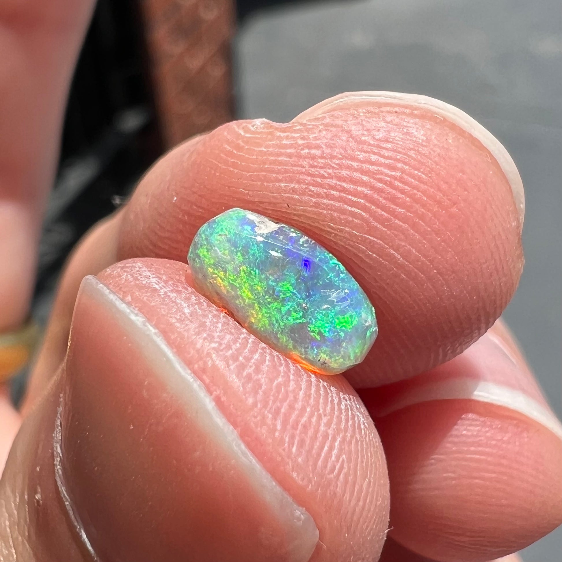 A loose, semi-crystal opal from Australia.  The opal predominantly show green and orange colors.