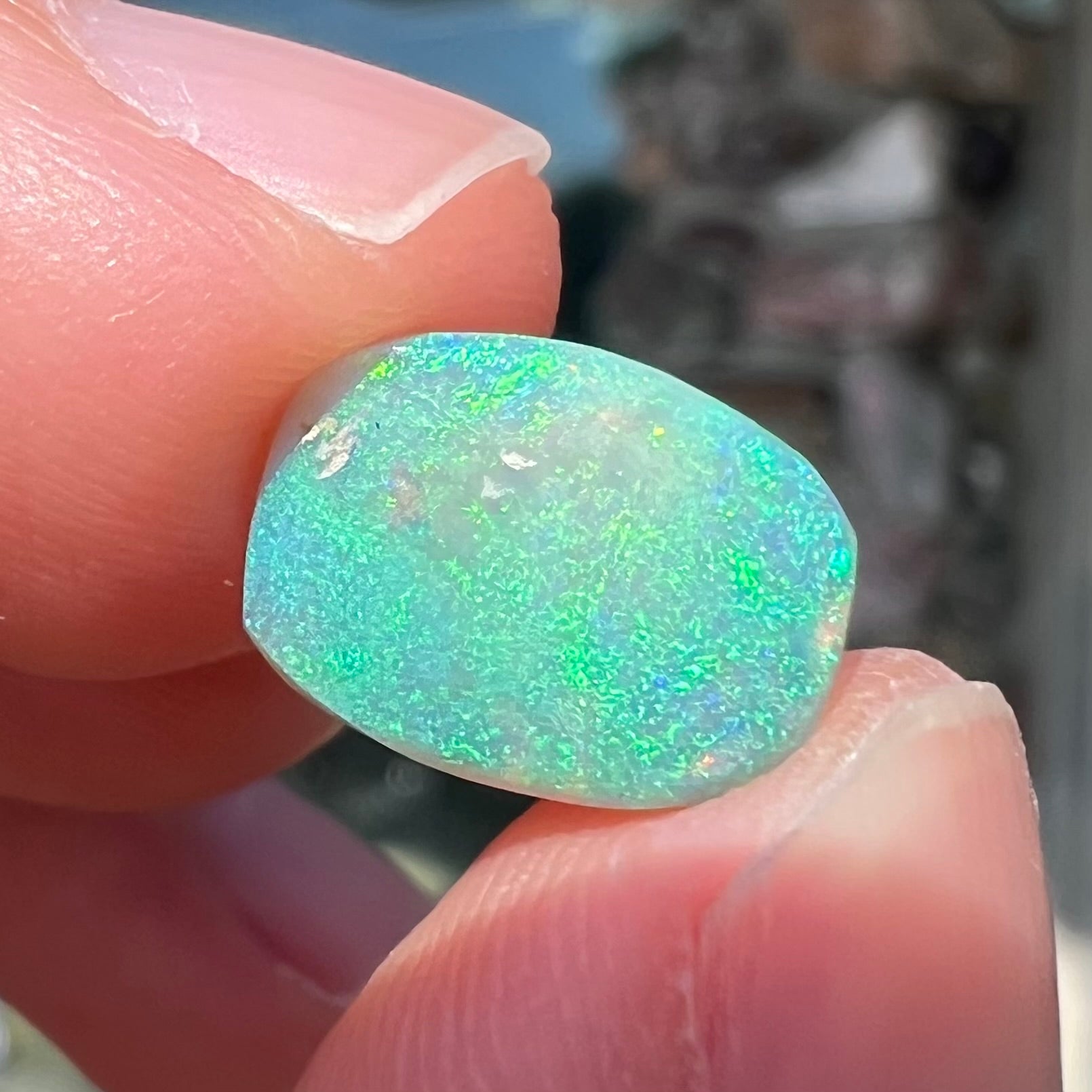 A 2.40ct barrel shaped Lightning Ridge semi-crystal opal.  The stone has blue and green colors.