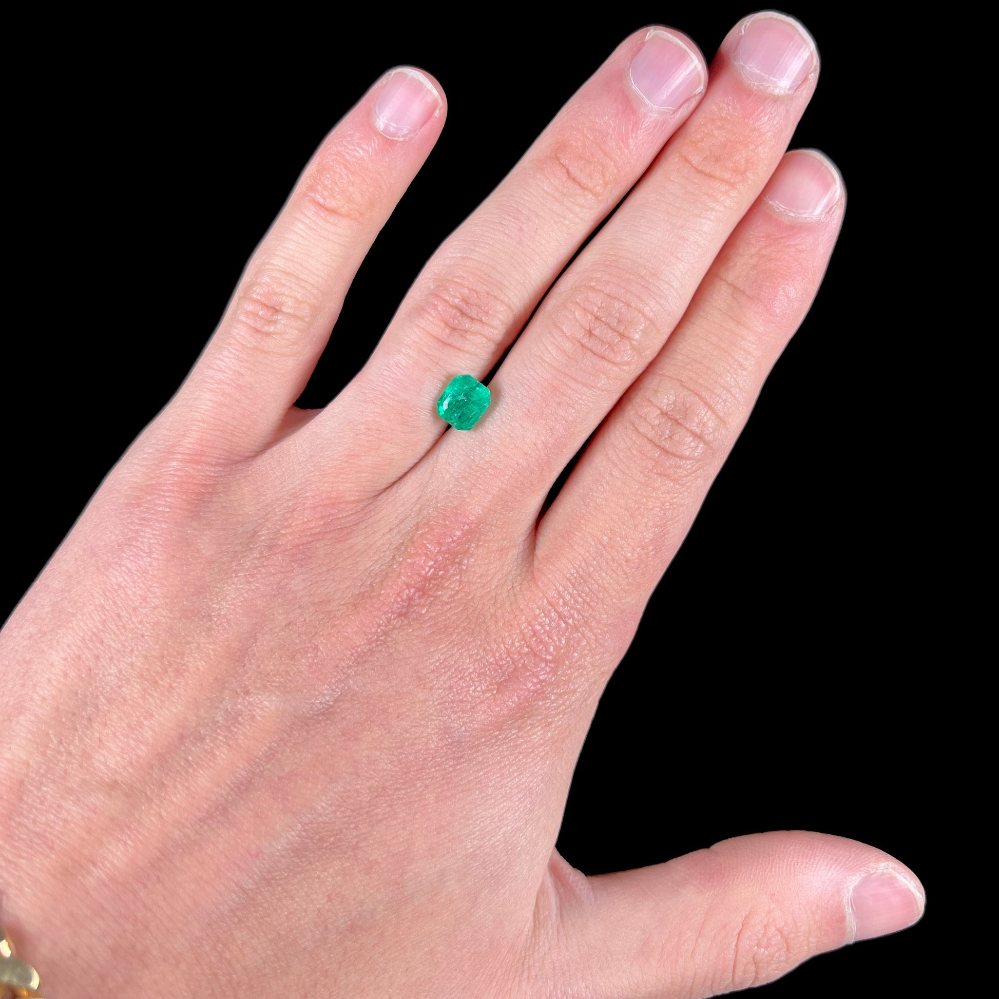 A loose, emerald cut natural emerald gemstone.