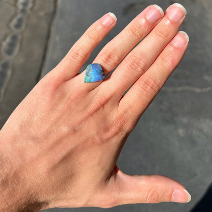 A loose, freeform shaped double-sided boulder opal stone from Quilpie, Australia.  One side is blue, the other is white.