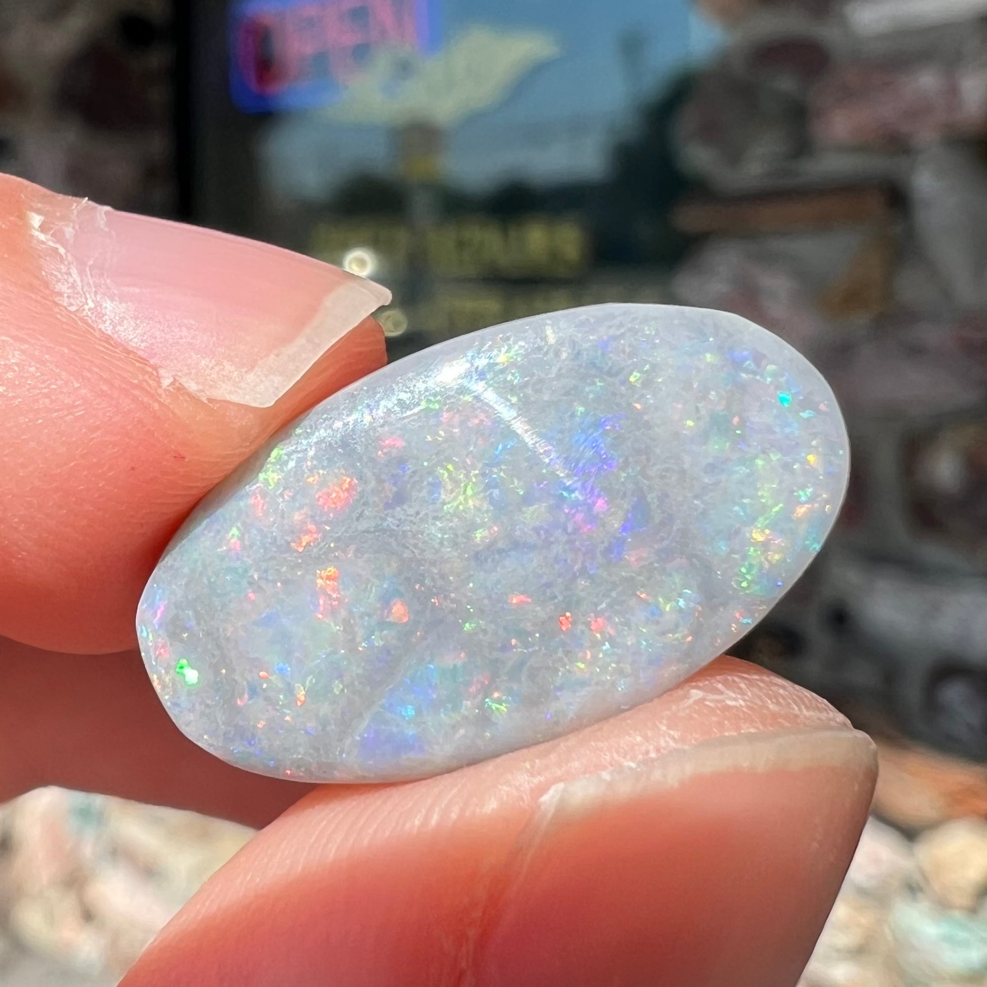 A loose, oval cut semi-black opal stone from Lightning Ridge, Australia.