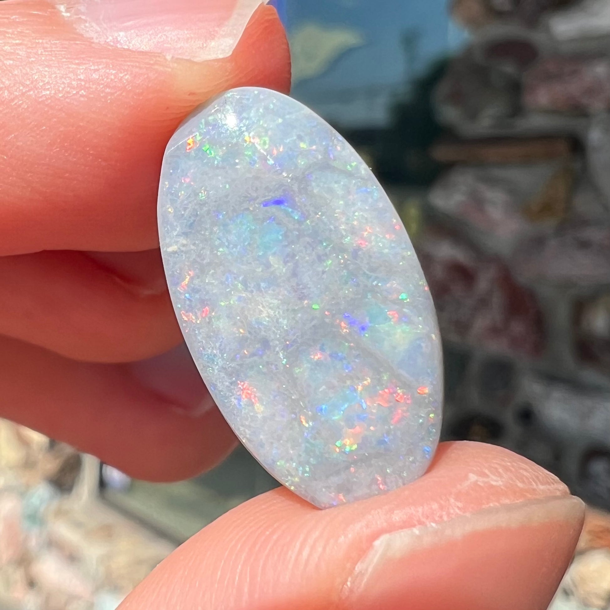 A loose, oval cut semi-black opal stone from Lightning Ridge, Australia.