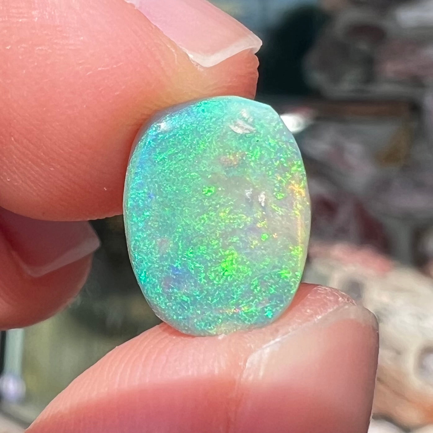 A 2.40ct barrel shaped Lightning Ridge semi-crystal opal.  The stone has blue and green colors.