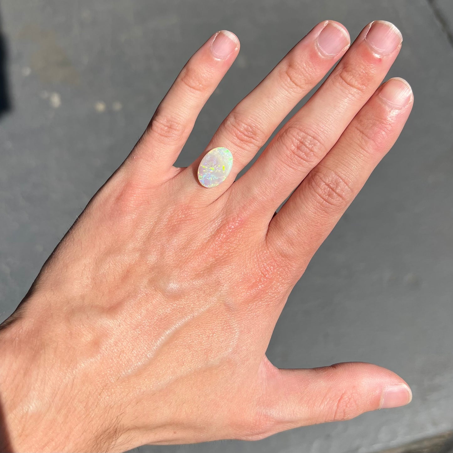 A double-sided opal stone from Coober Pedy, Australia.  The opal plays green, blue, and orange colors from the front and the back.