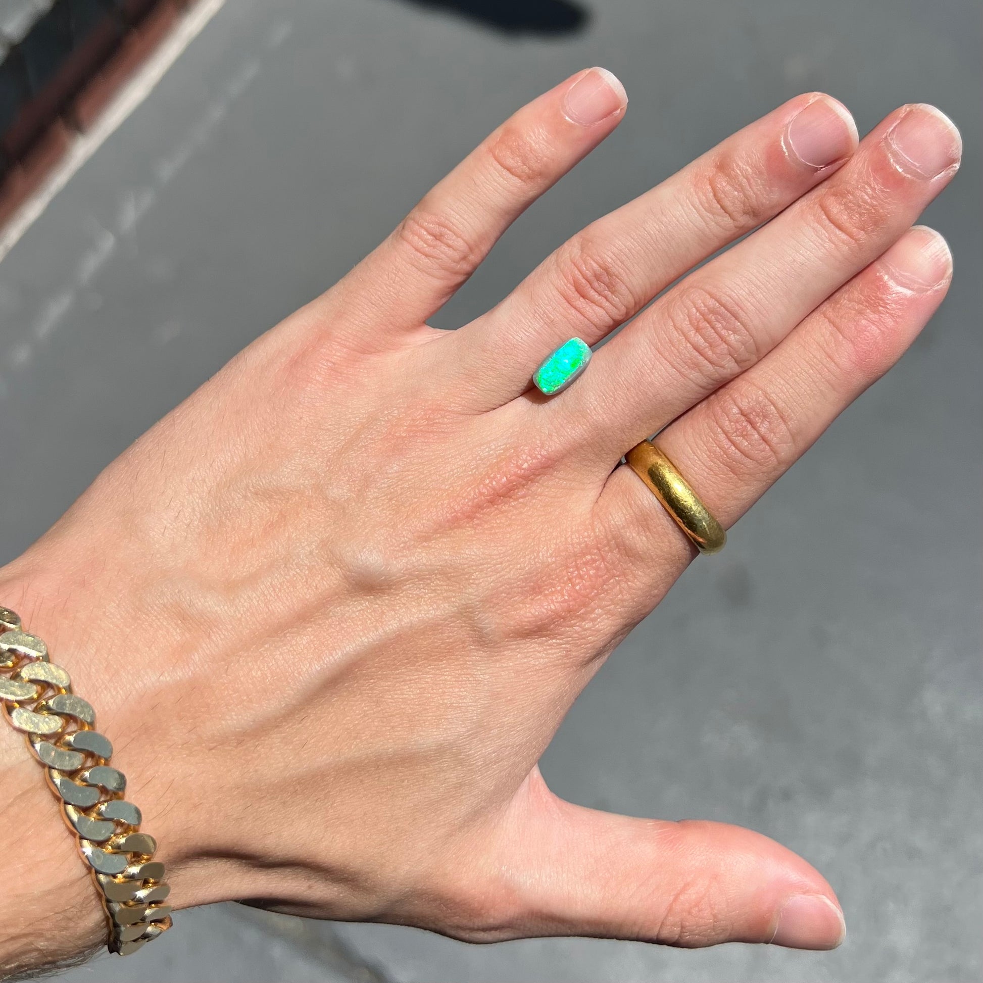 A loose semi-black opal from Lightning Ridge, Australia.  The opal flashes bright green and blue colors.