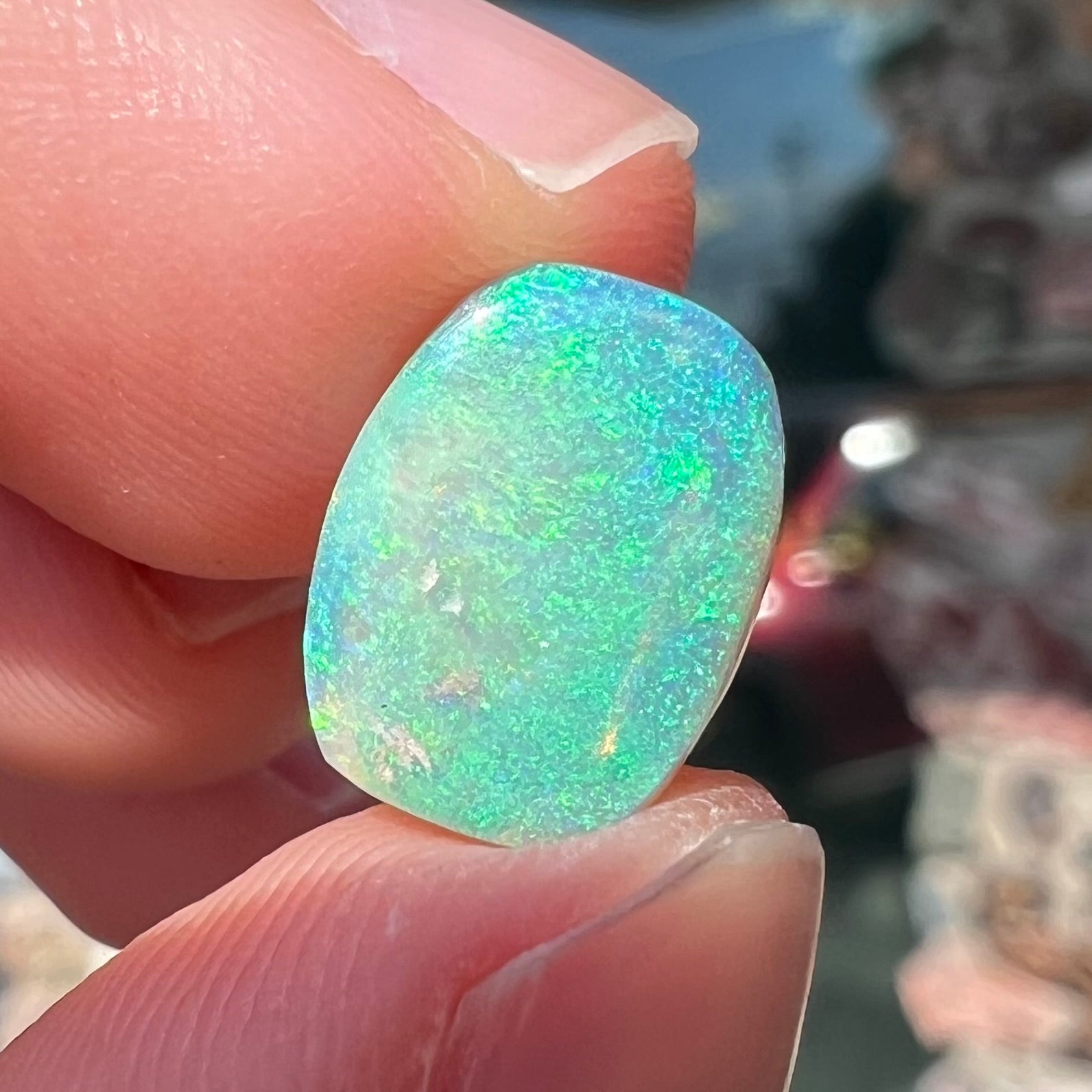 A 2.40ct barrel shaped Lightning Ridge semi-crystal opal.  The stone has blue and green colors.