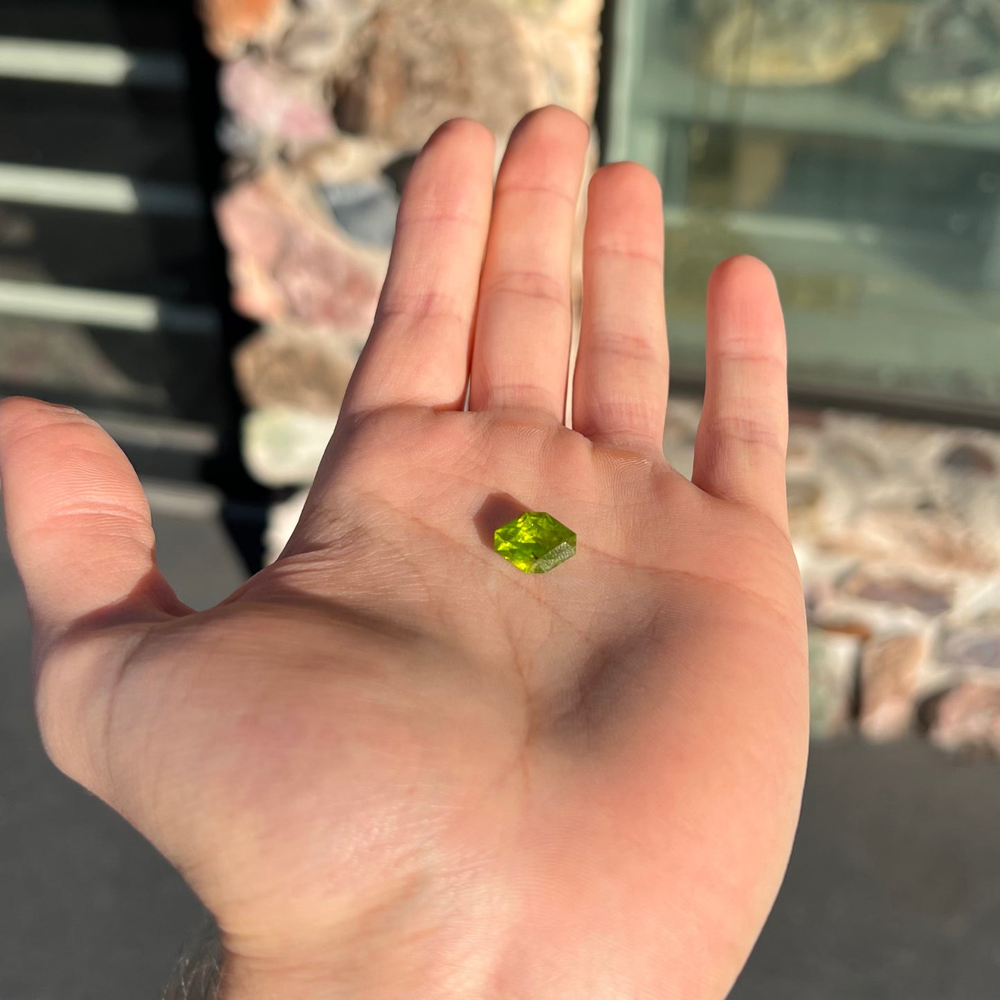 A loose, modified octagon peridot stone.  The stone is a yellow green color.