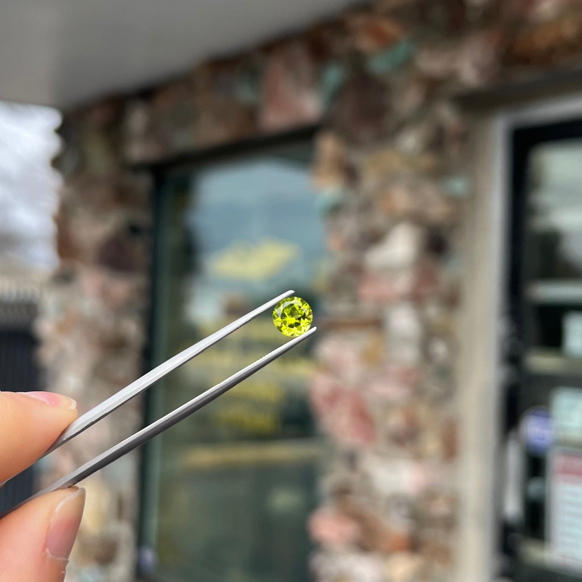 A loose, round brilliant cut peridot gemstone.