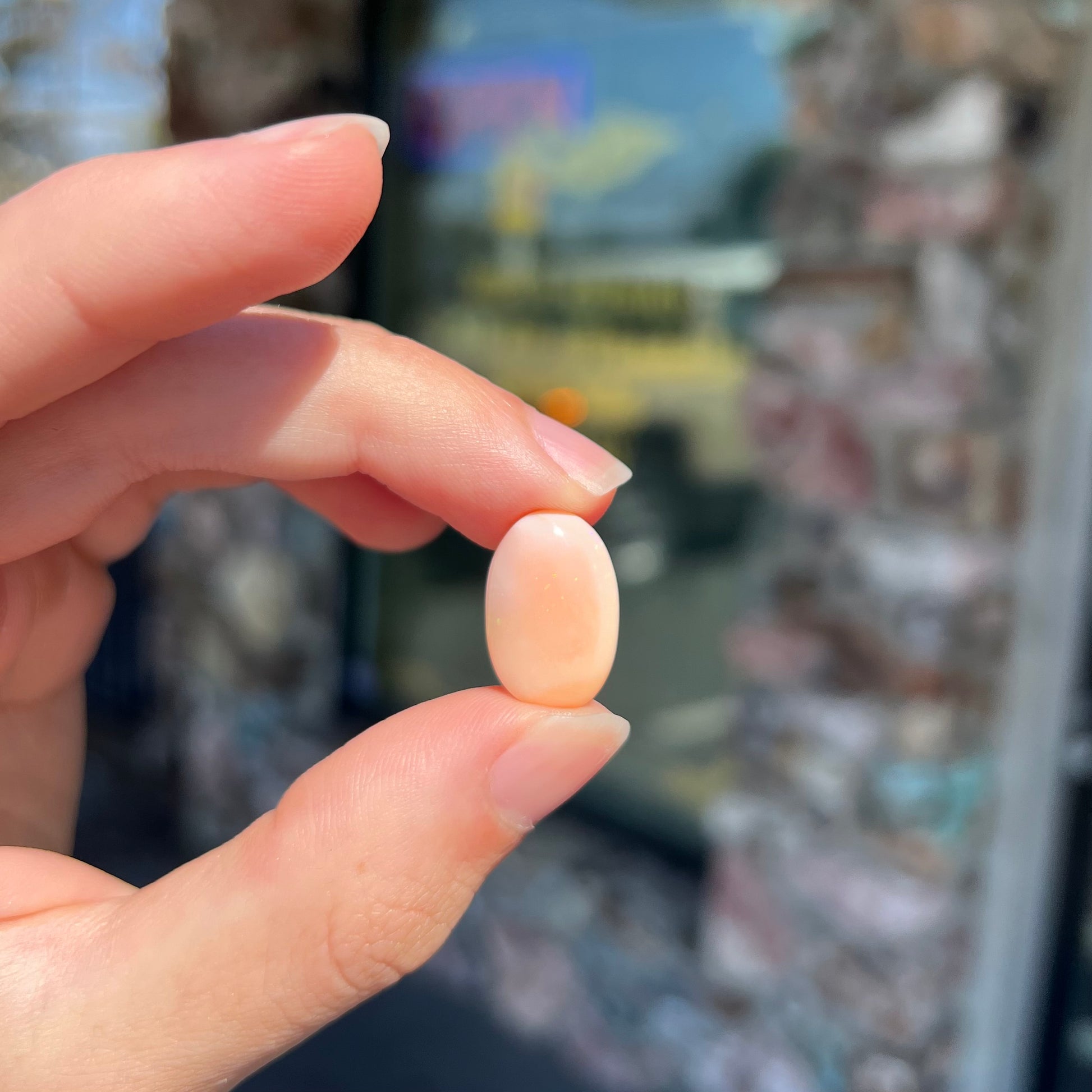 A loose, oval cabochon cut Peruvian opal stone.  The opal is a coral pink color.