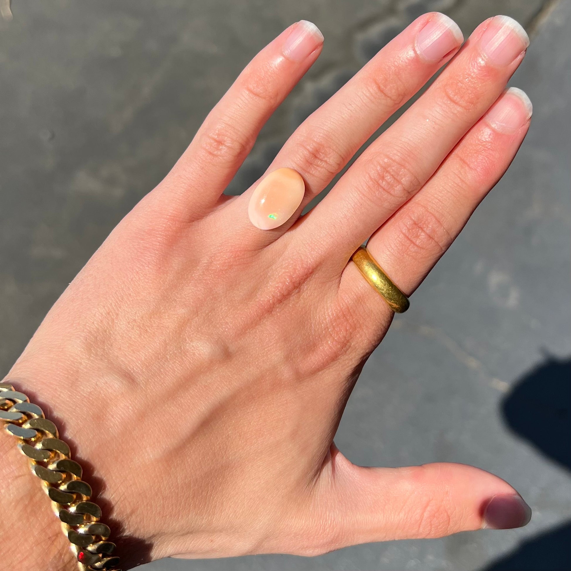 A loose, oval cabochon cut Peruvian opal stone.  The opal is a coral pink color.