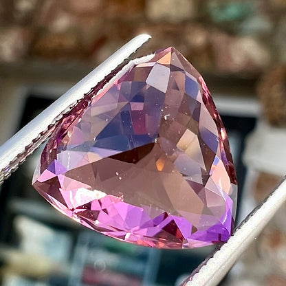 A loose, checkerboard trillion cut purple tourmaline gemstone.