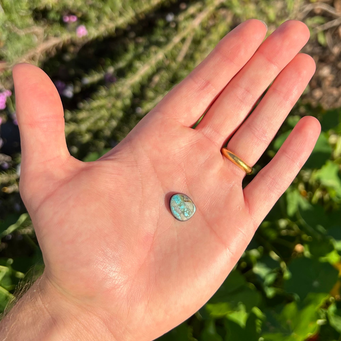 A loose, freeform pear shaped cabochon cut Valley Blue turquoise stone from Lander County, Nevada.  The stone is blue and green with quartz inclusions.