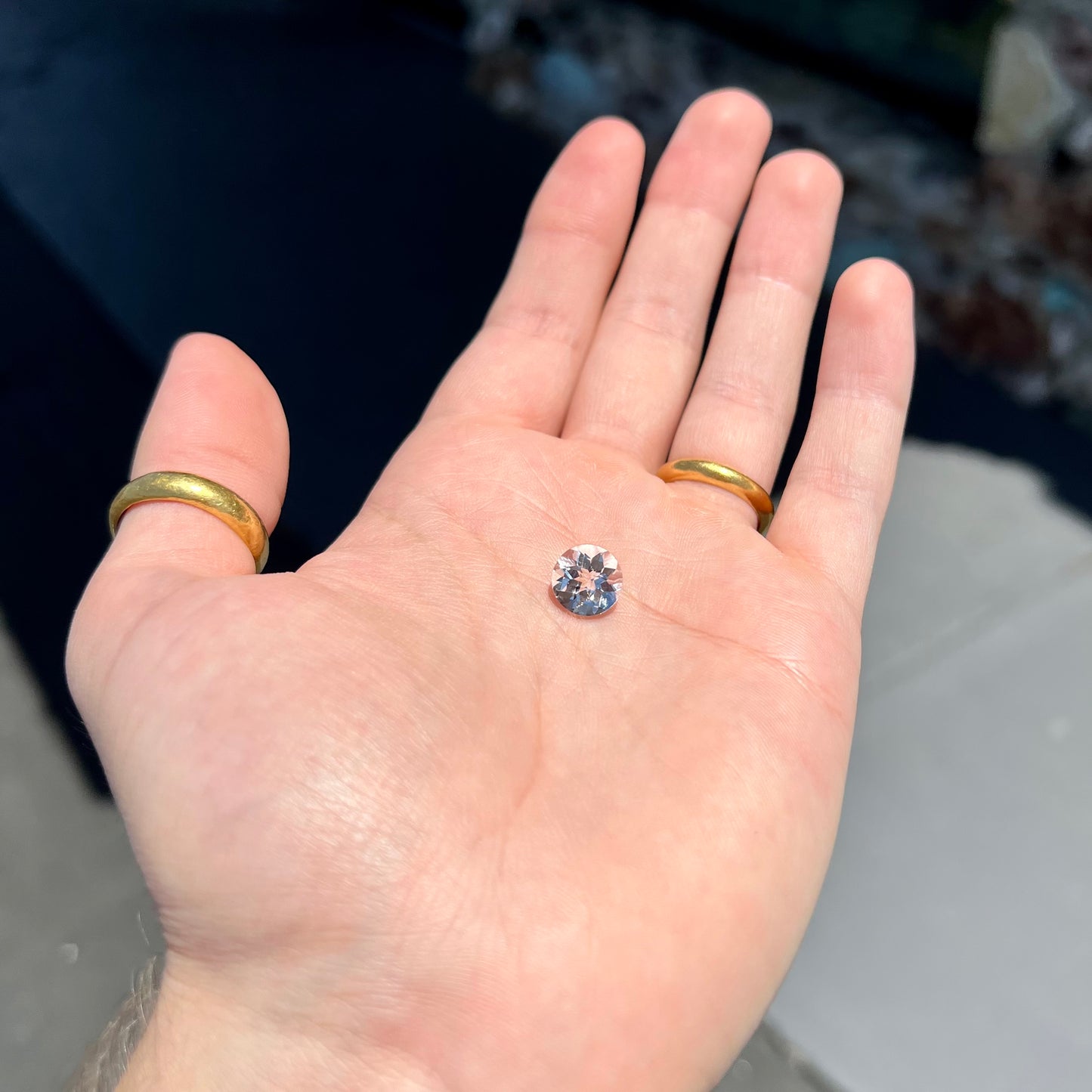 A loose, round checkerboard cut white topaz gemstone.