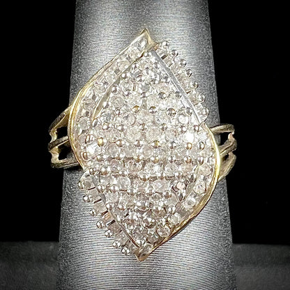 A ladies' yellow gold and diamond cluster ring.  The diamonds are round and baguette shaped, and the ring is navette shaped.