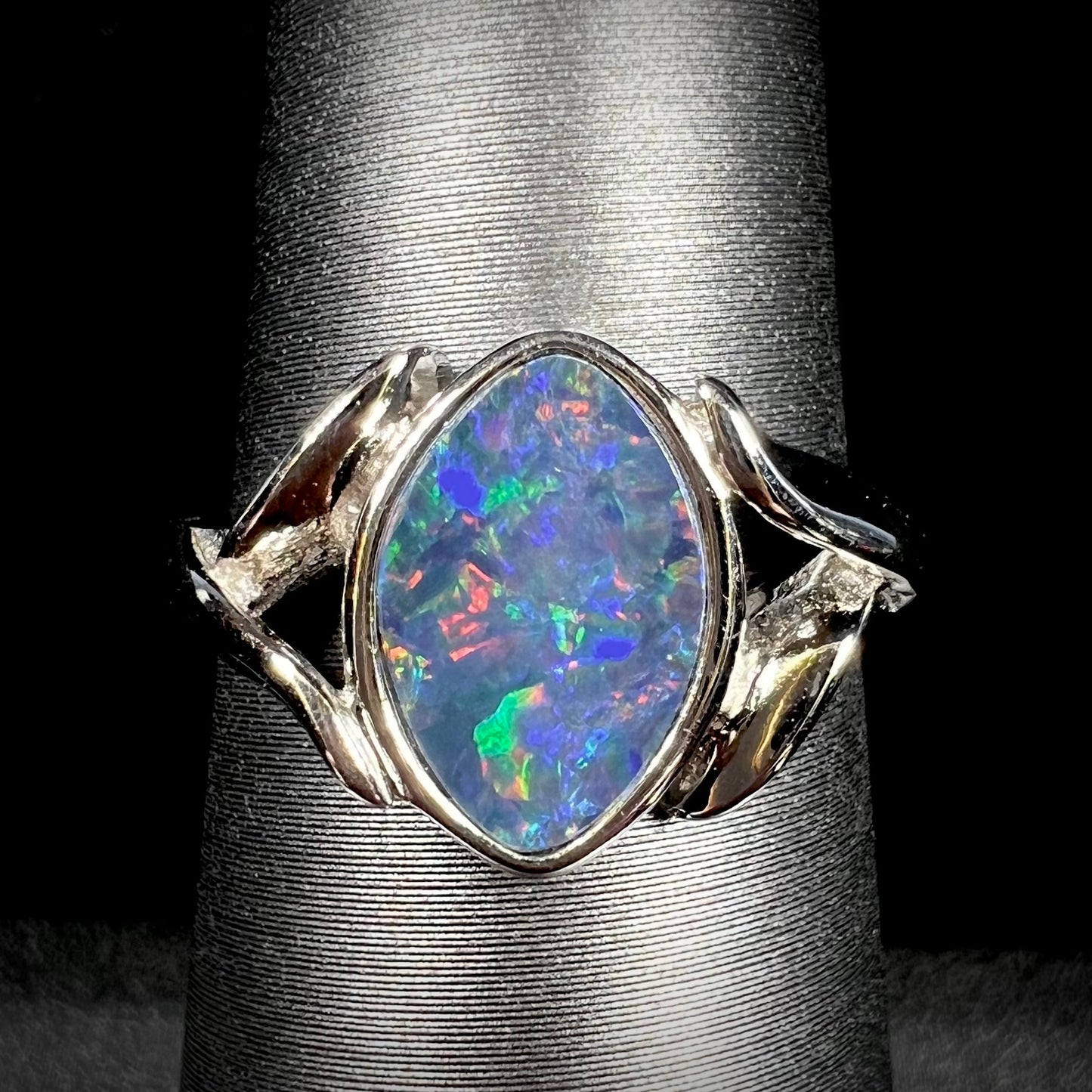 A sterling silver ring mounted with a marquise cut black opal doublet.  The opal has red fire.