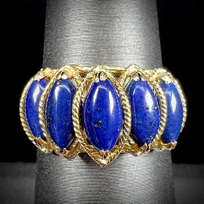 A ladies' five stone marquise cabochon cut lapis lazuli ring in yellow gold.