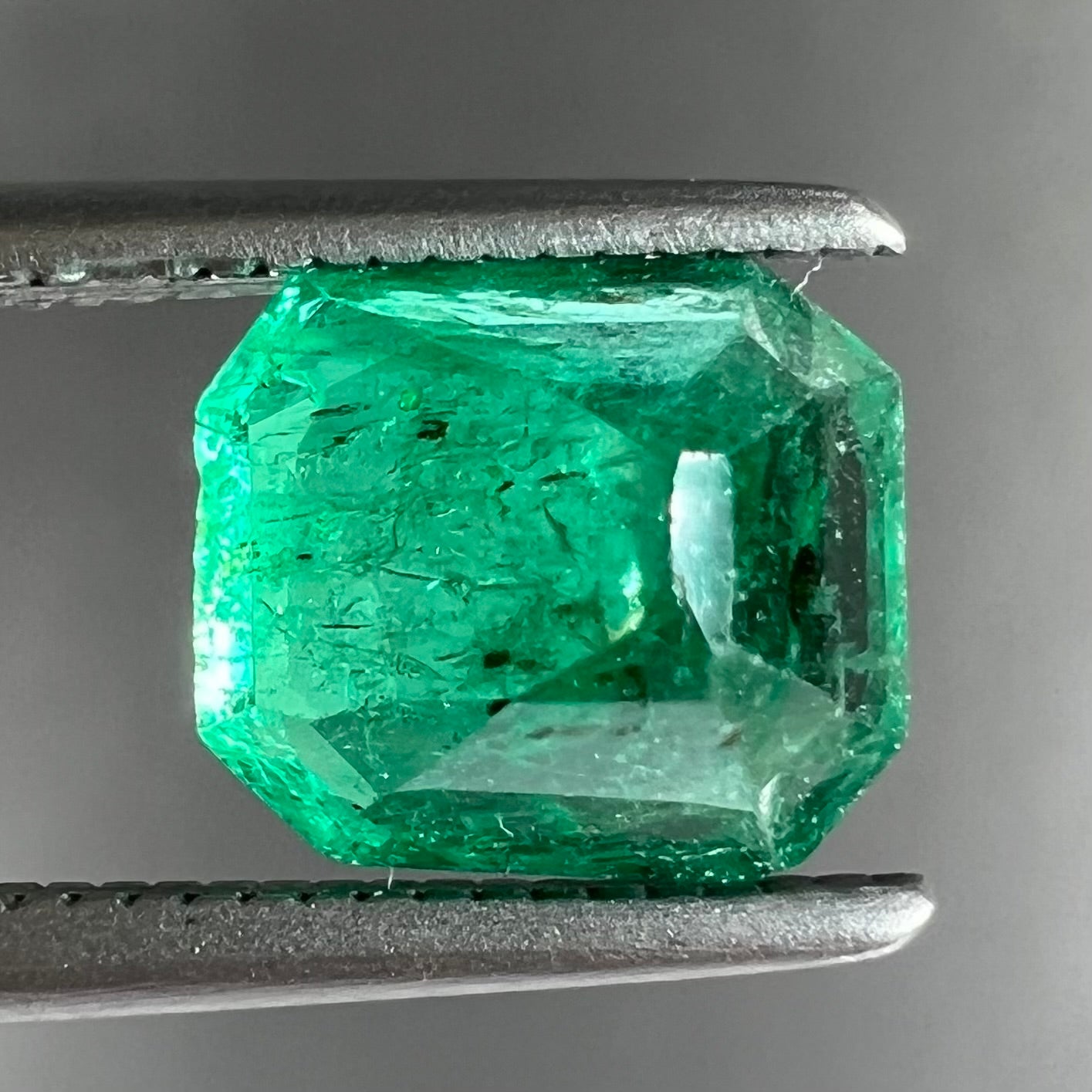 A loose, emerald cut natural emerald gemstone.