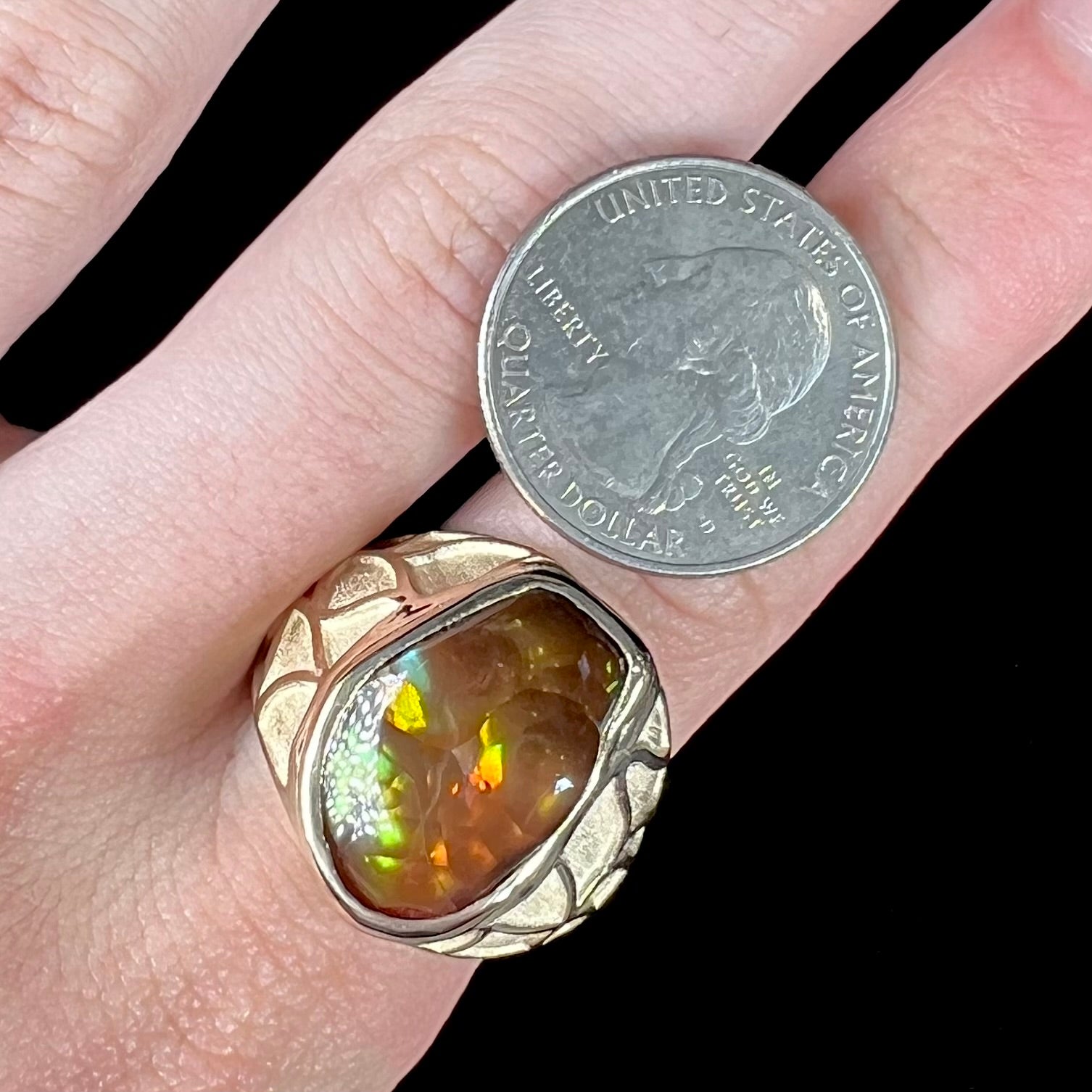 A men's heavy yellow gold ring mounted with a Mexican fire agate stone.  The shank of the ring is textured.