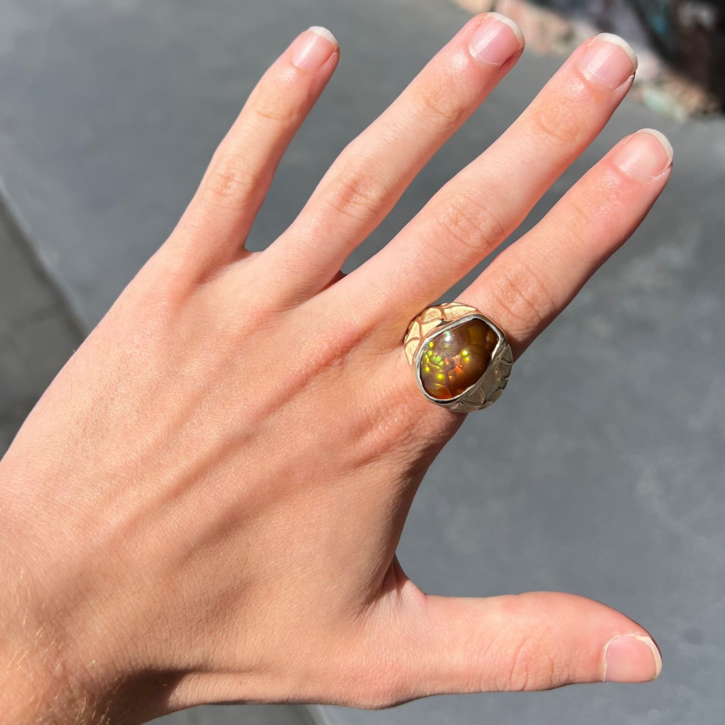 A men's heavy yellow gold ring mounted with a Mexican fire agate stone.  The shank of the ring is textured.