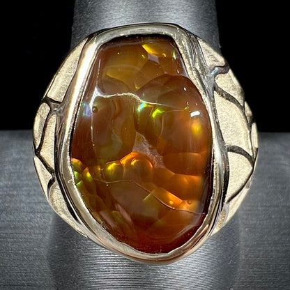 A men's heavy yellow gold ring mounted with a Mexican fire agate stone.  The shank of the ring is textured.